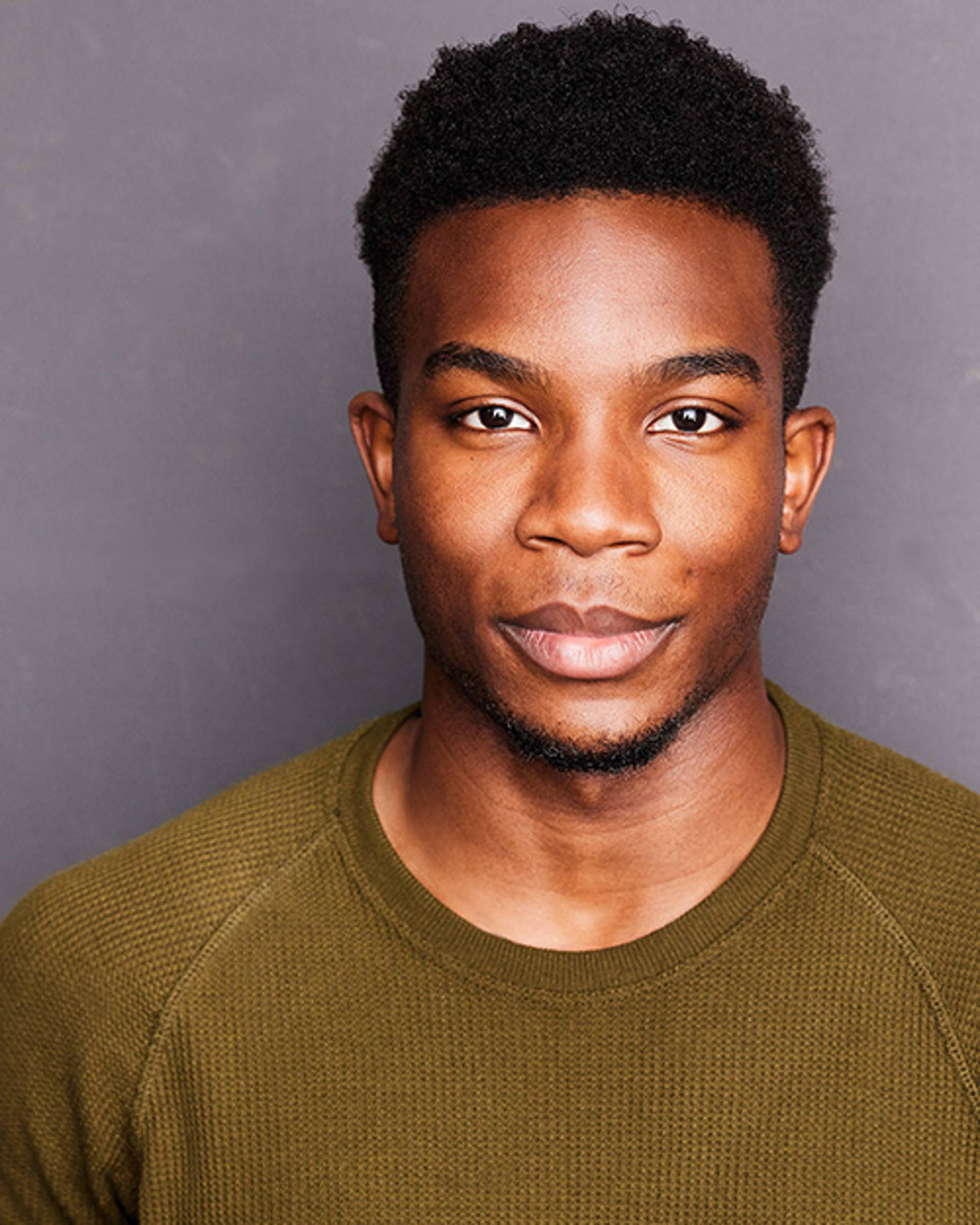 Headshot of an African American man with short dark hair and brown eyes
