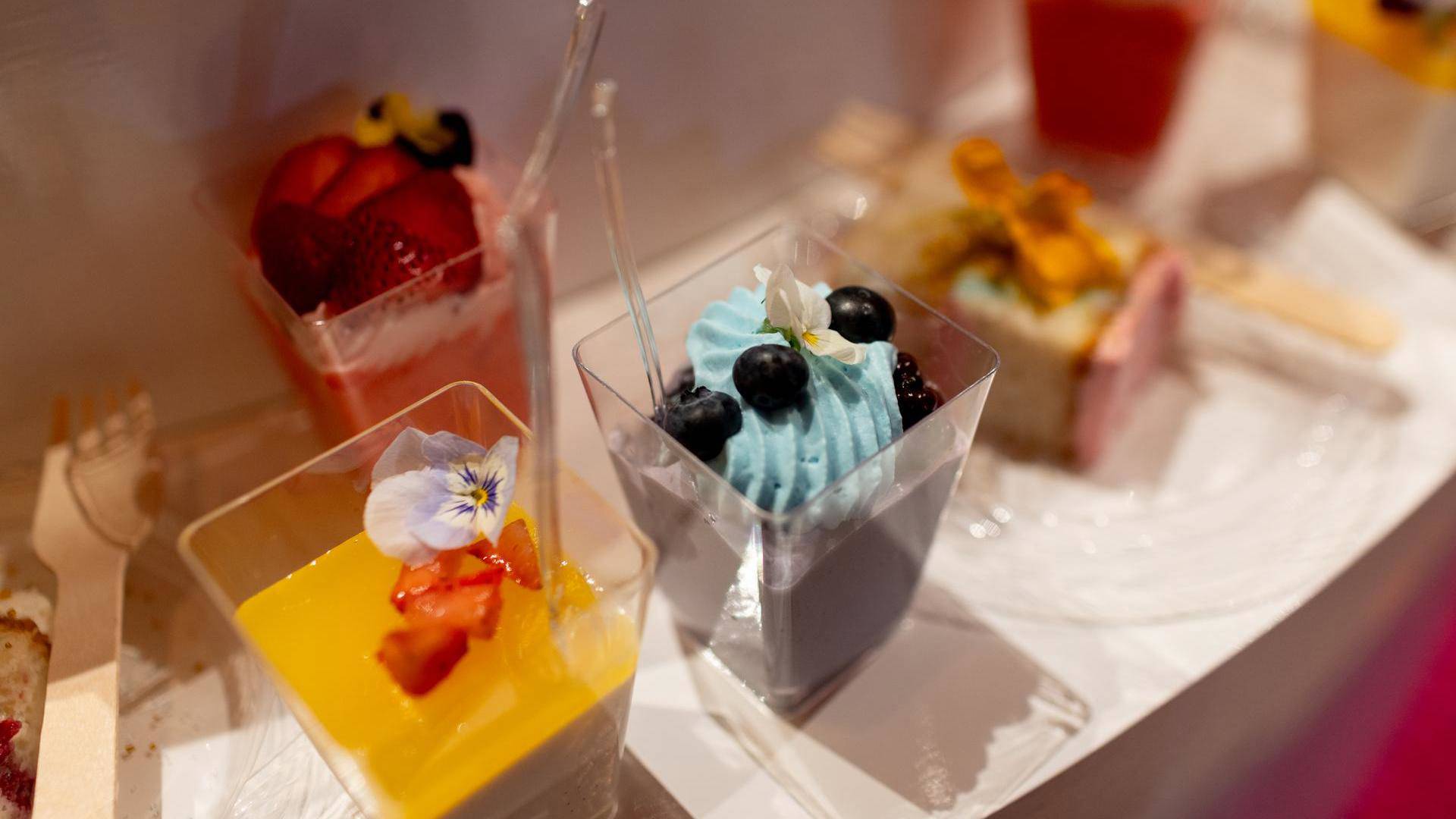 Colorful desserts in clear containgers.