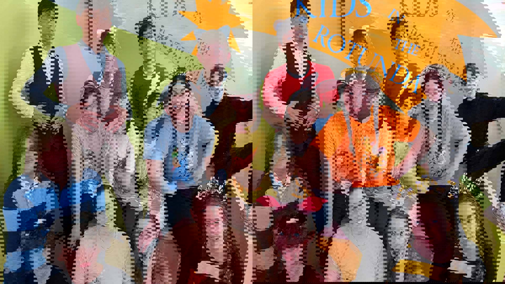 A group of high school theater kids posing for a photo with silly faces and some minor costume headwear