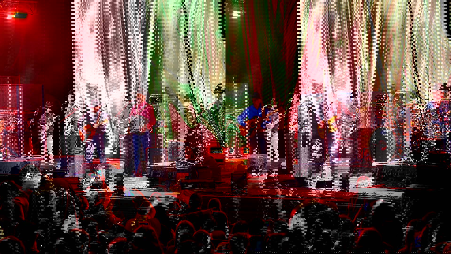 Intocable, a six-piece band performing on stage to a crowd.