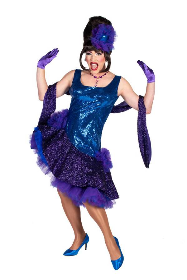 A drag performer with a beehive hairdo, blue dress, red lipstick and purple gloves striking a dramatic pose.