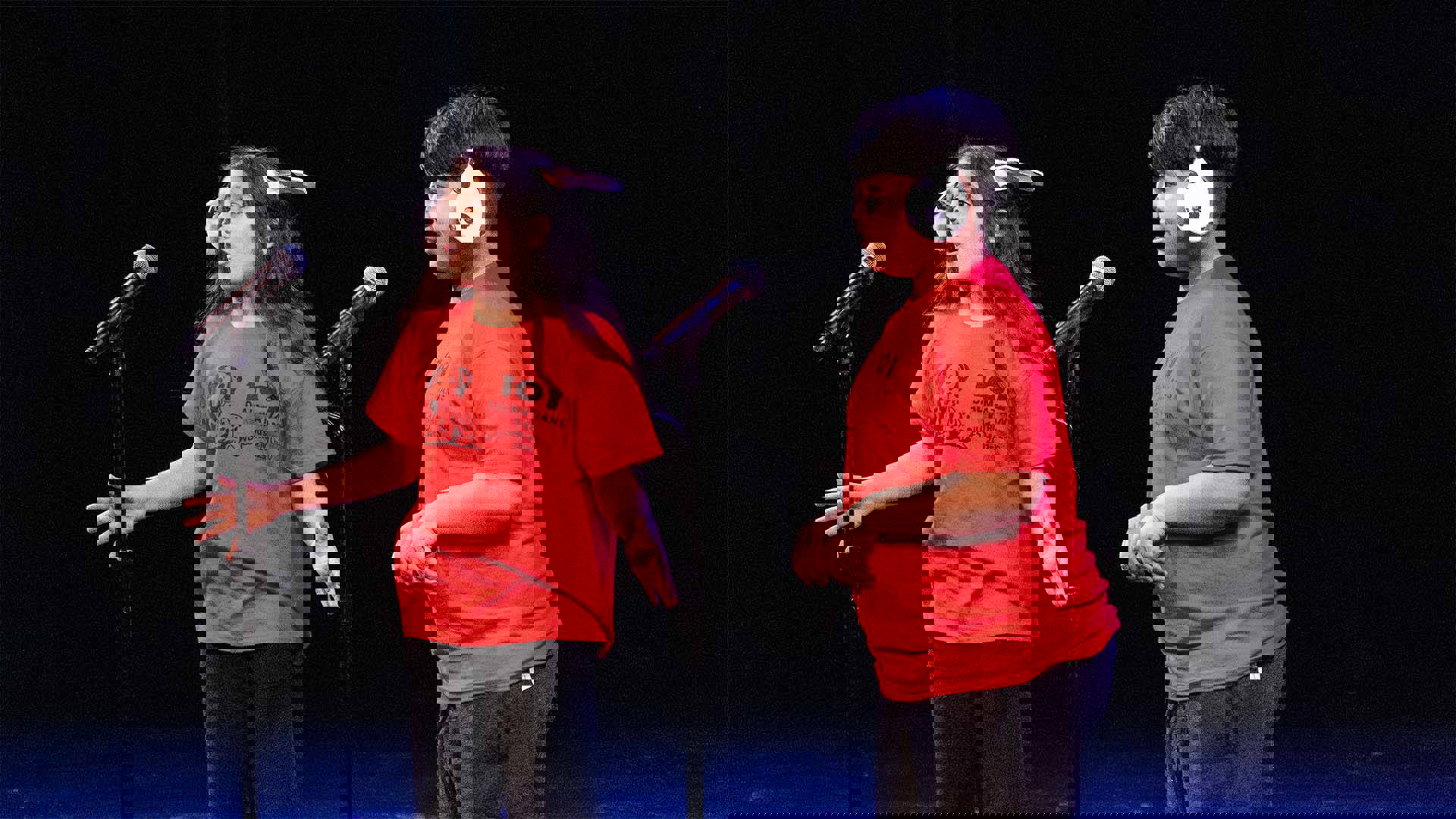 Two young students in red shirts and puppy ear headwear performing on a dark stage. 
