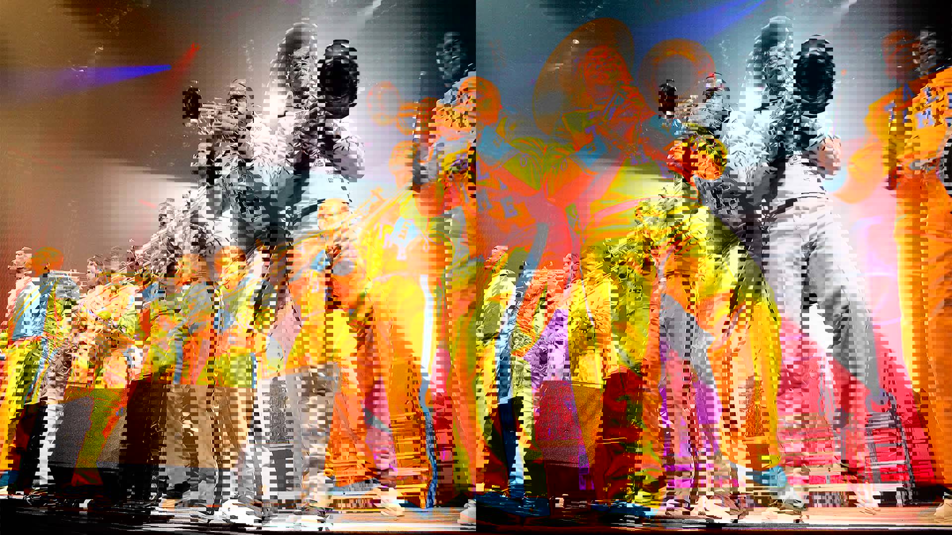 Drumline Live's African-American marching band performing on stage. The brass section is standing close to the stage edge.