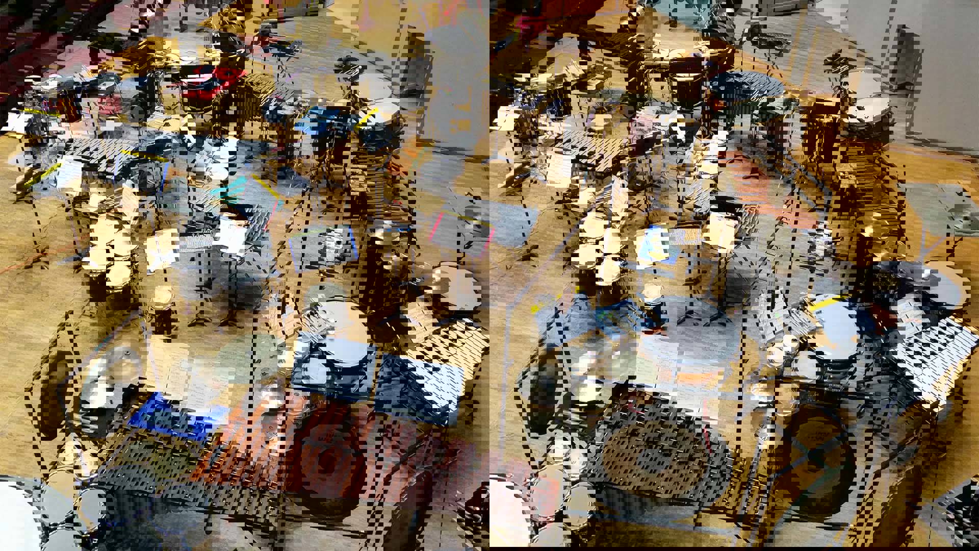 A stage filled to the brim with a variety of drums, cymbals, mallet instruments, tam tams, gongs, and timpani.