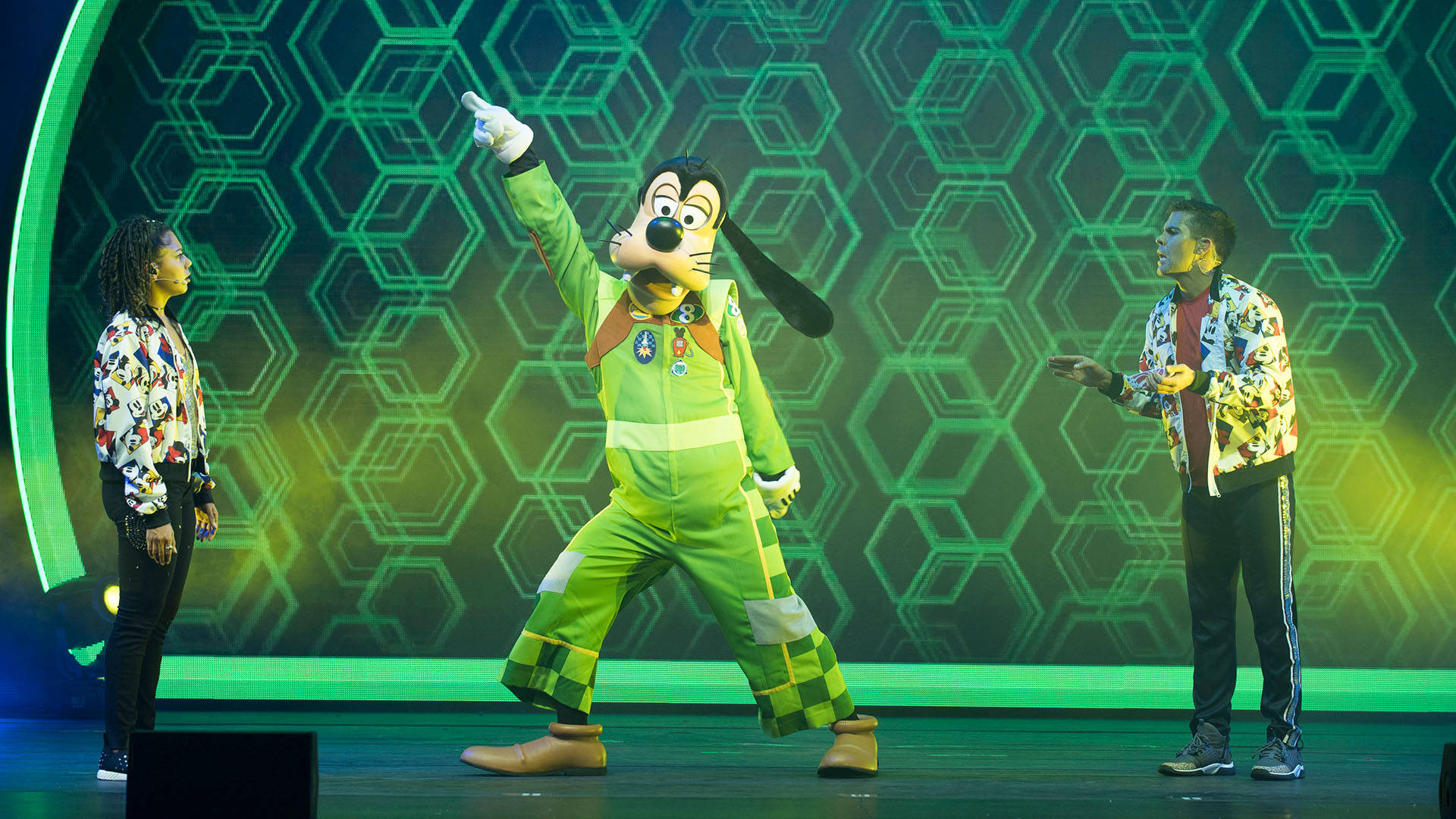 Goofy costume in a green outfit striking a disco pose.