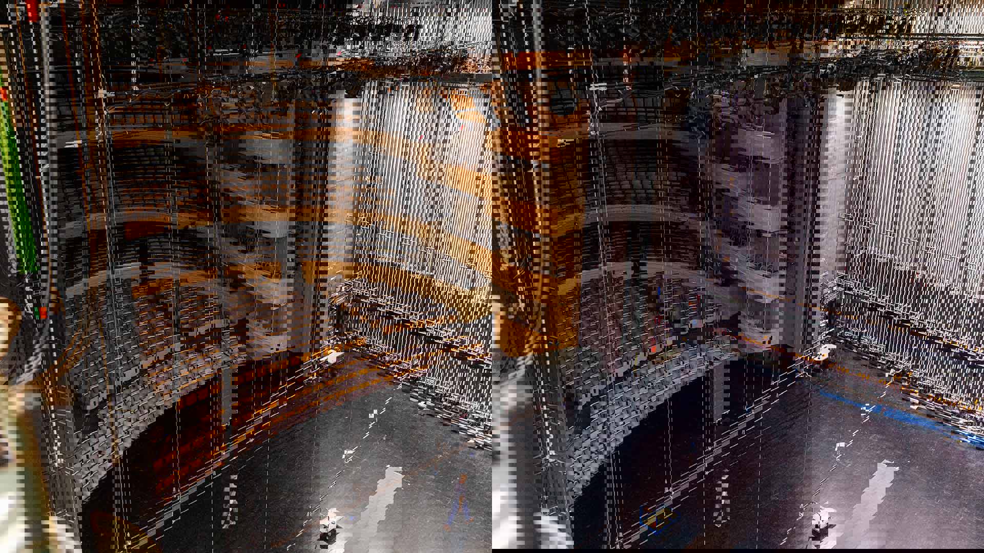 View from midway up behind the stage of Overture Hall, showing the seats of Orchestra through Balcony and lighting above the stage.