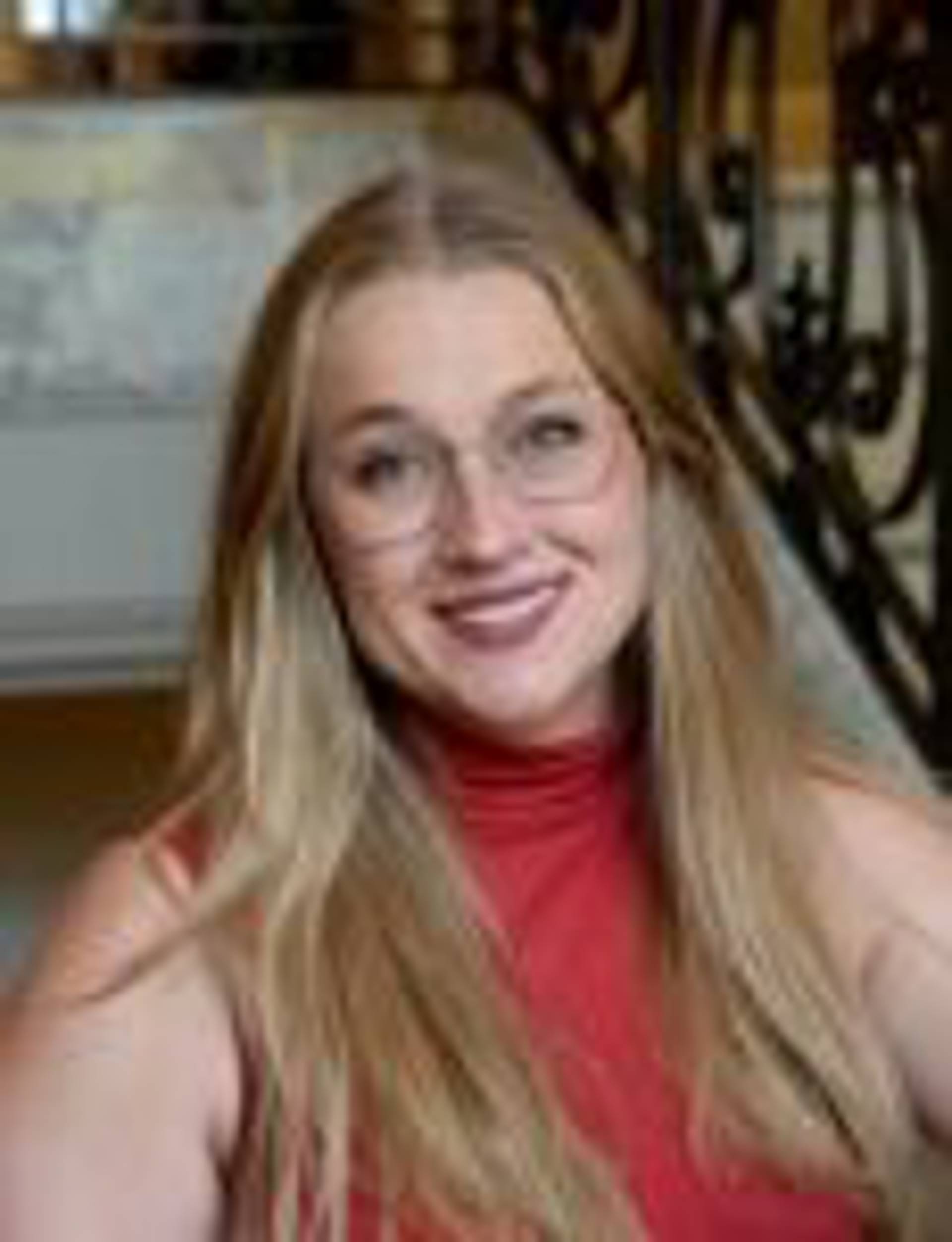 Headshot of a woman with long blond hair and a red top.