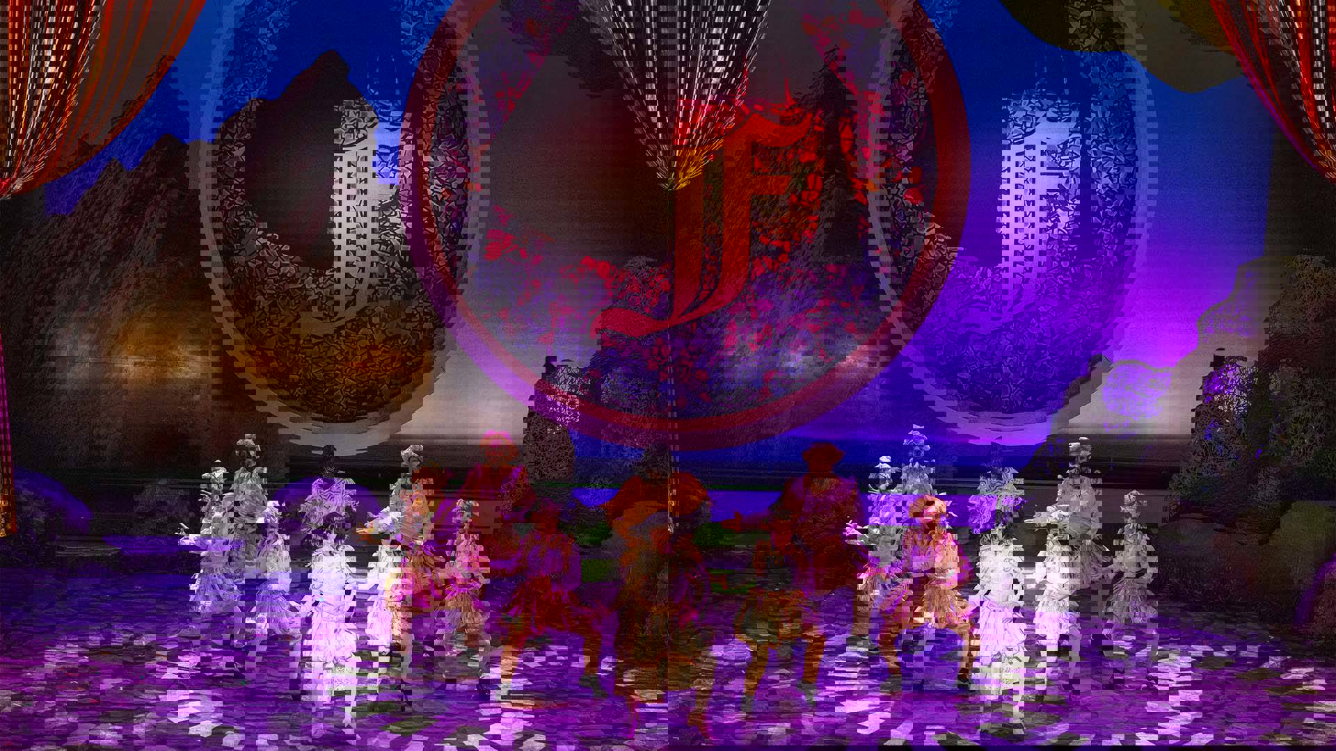 Lord Farquad, a light complexion person with a black haired bob with bands in a white regal costume performing with the ensemble.