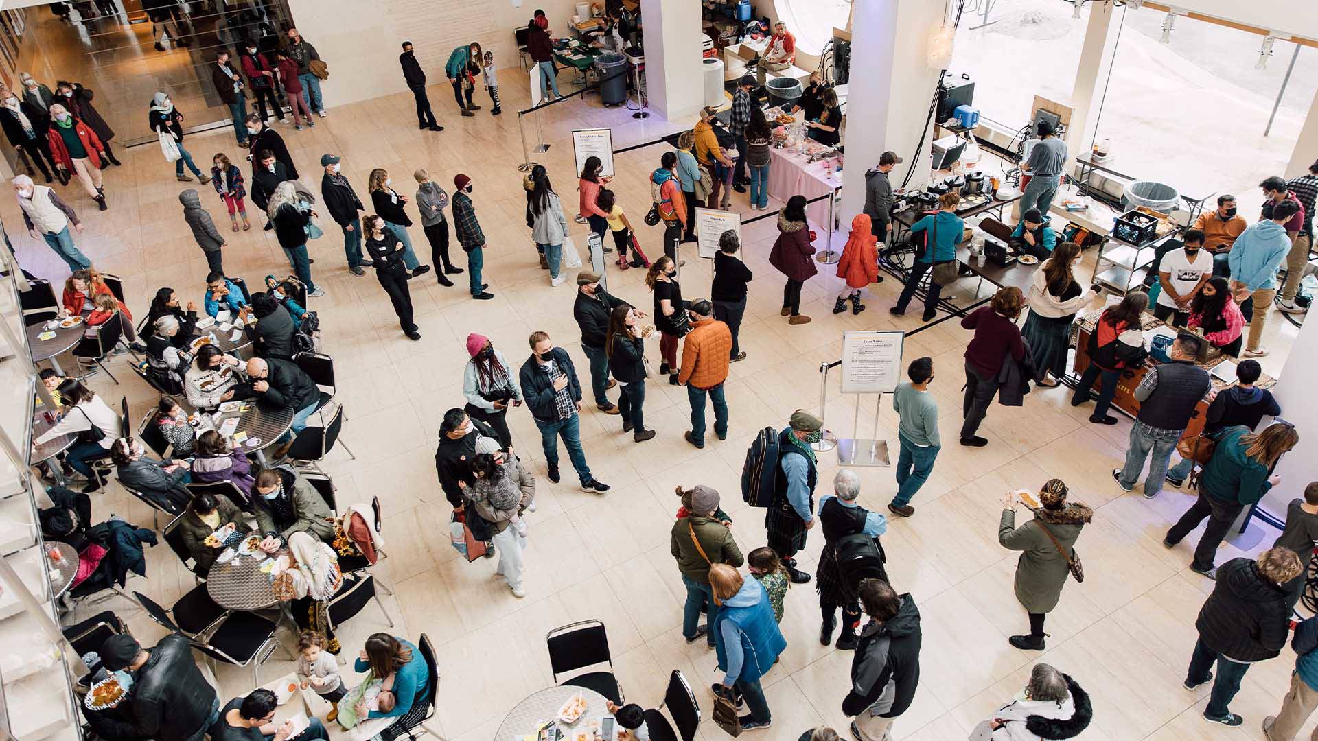 An aerial view of many patrons standing in Overture Hall Lobby.