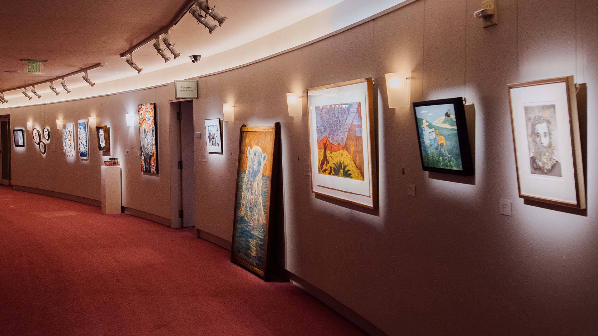 Paintings hanging on a curved wall.