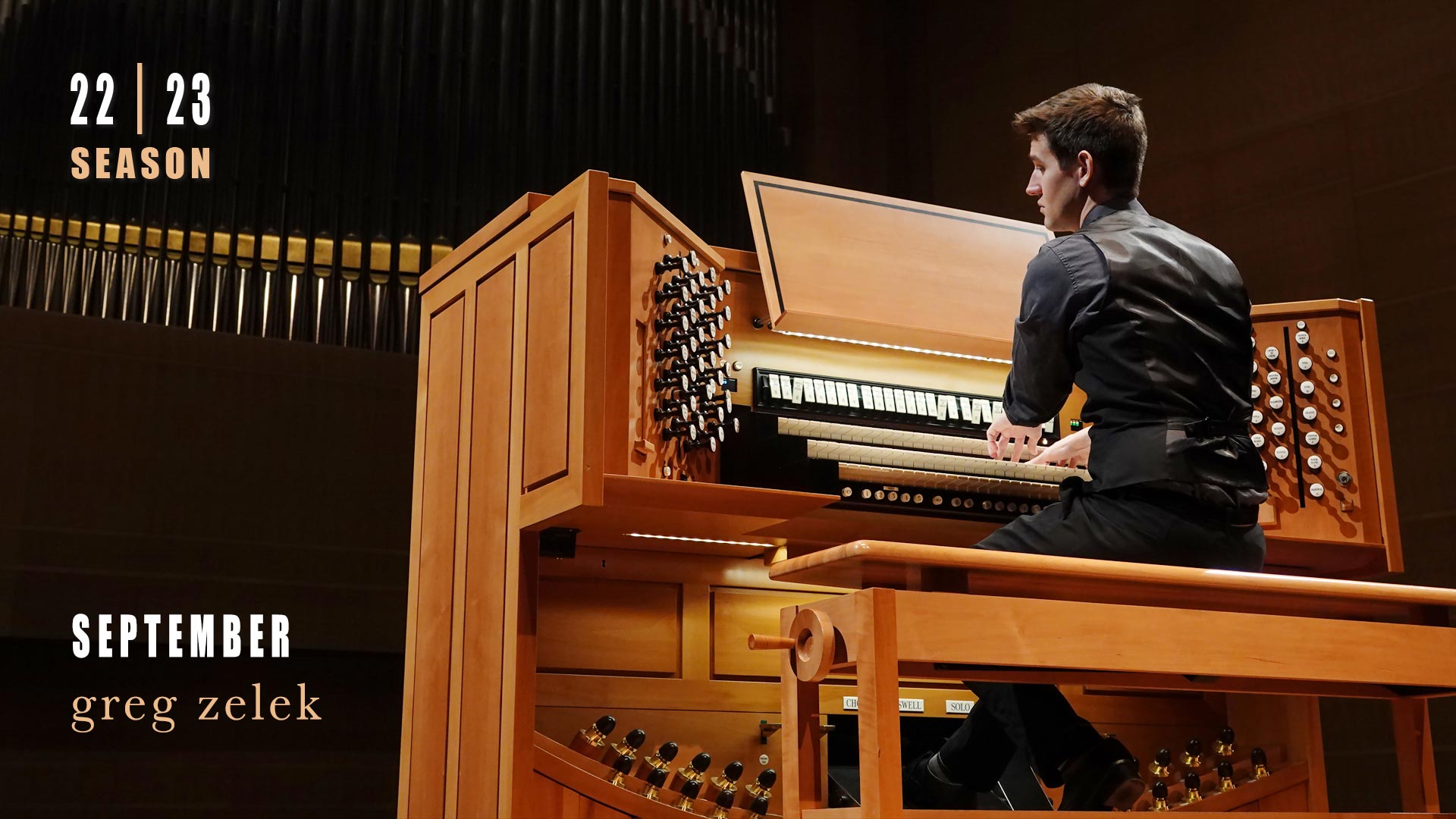 Banner text reads: September greg zelek. A young white man playing an organ console. He has a dark dress shirt and dark vest on.