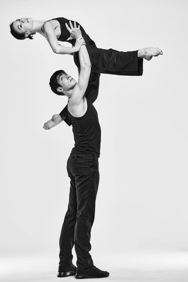 Greyscael image of two dancers in black outfits.
