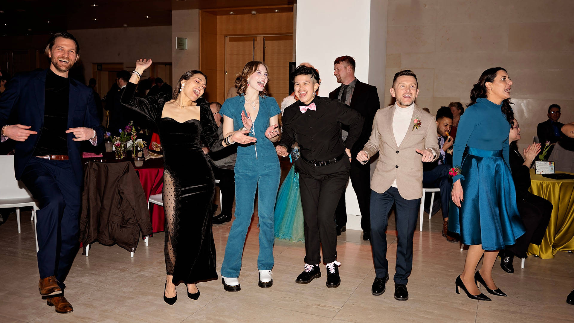 A line of people smiling and dancing.