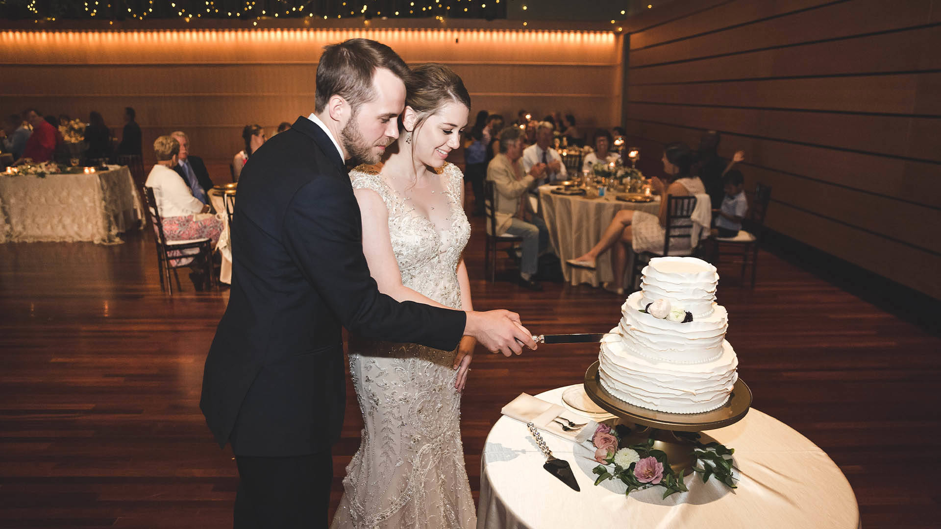 A bride and groom cutting their cake.