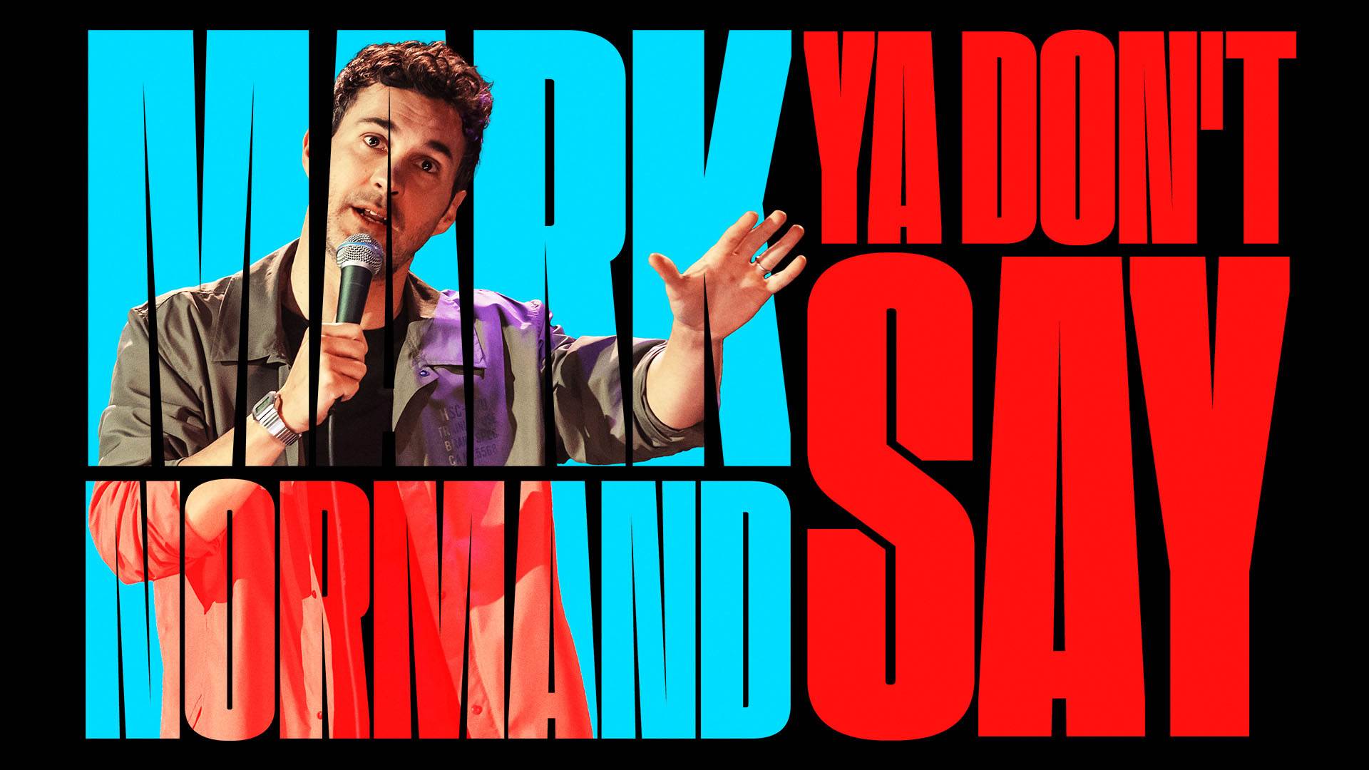 Banner text reads: "Mark Normand Ya Don't Say". A young caucasian man with short brown hair in a tan shirt is speaking into a microphone with his hand outstretched. The lettering is large and in blue and red colors.