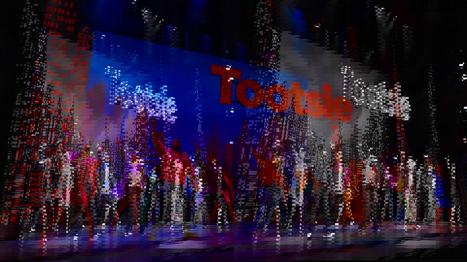 The cast of Tootsie dancing in unison on stage.