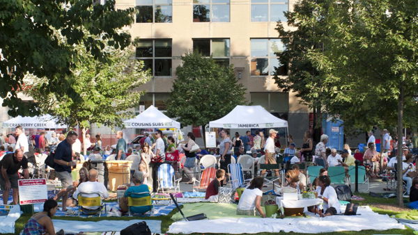 People picnicking in front of food vendors on the capitol square. 