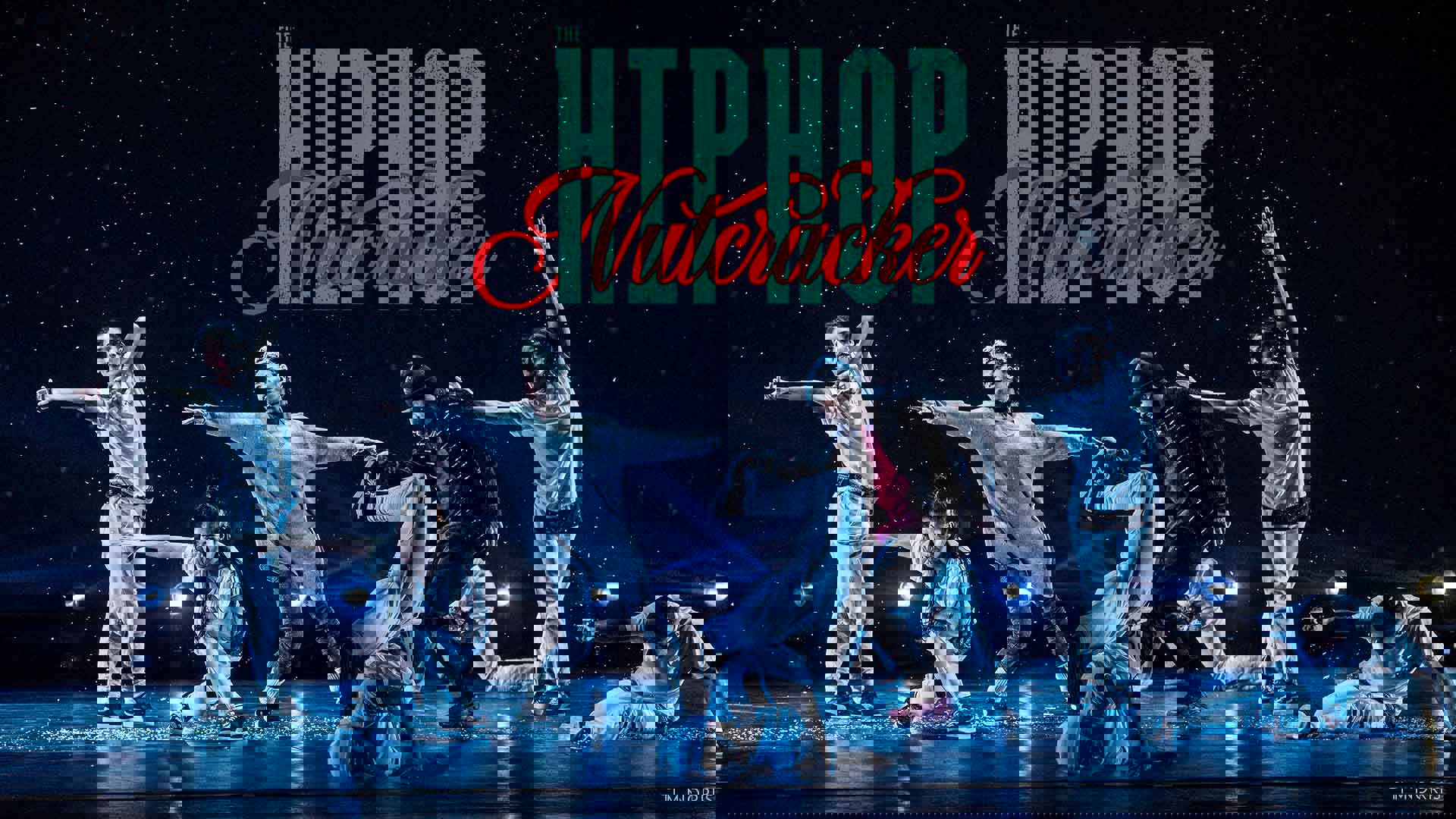 Seven hip-hop dancers in stylish baggy clothing strike dramatic break-dance poses on a stage