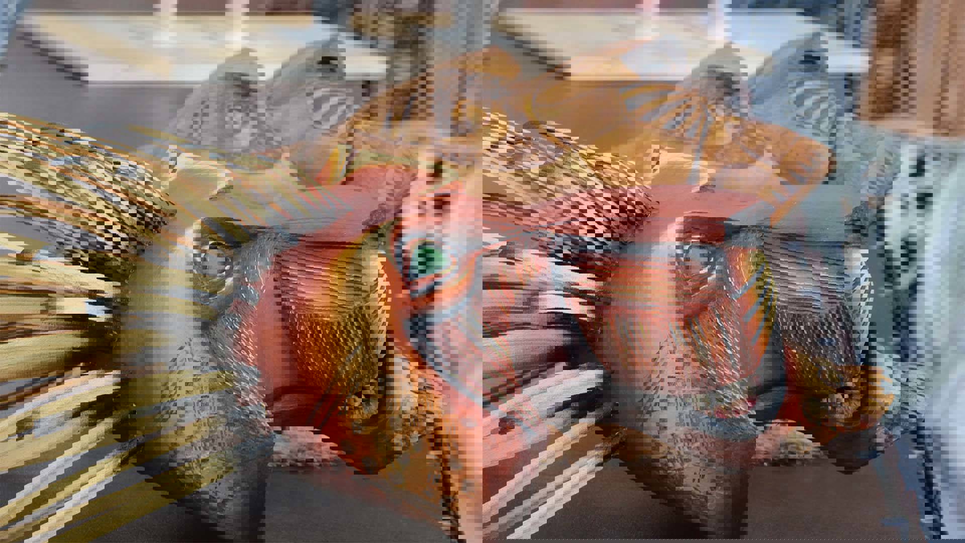 Two wooden lion masks sitting on a table.