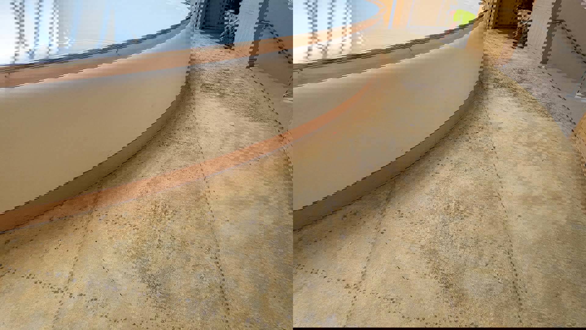 Tan floor that has been stripped of carpet