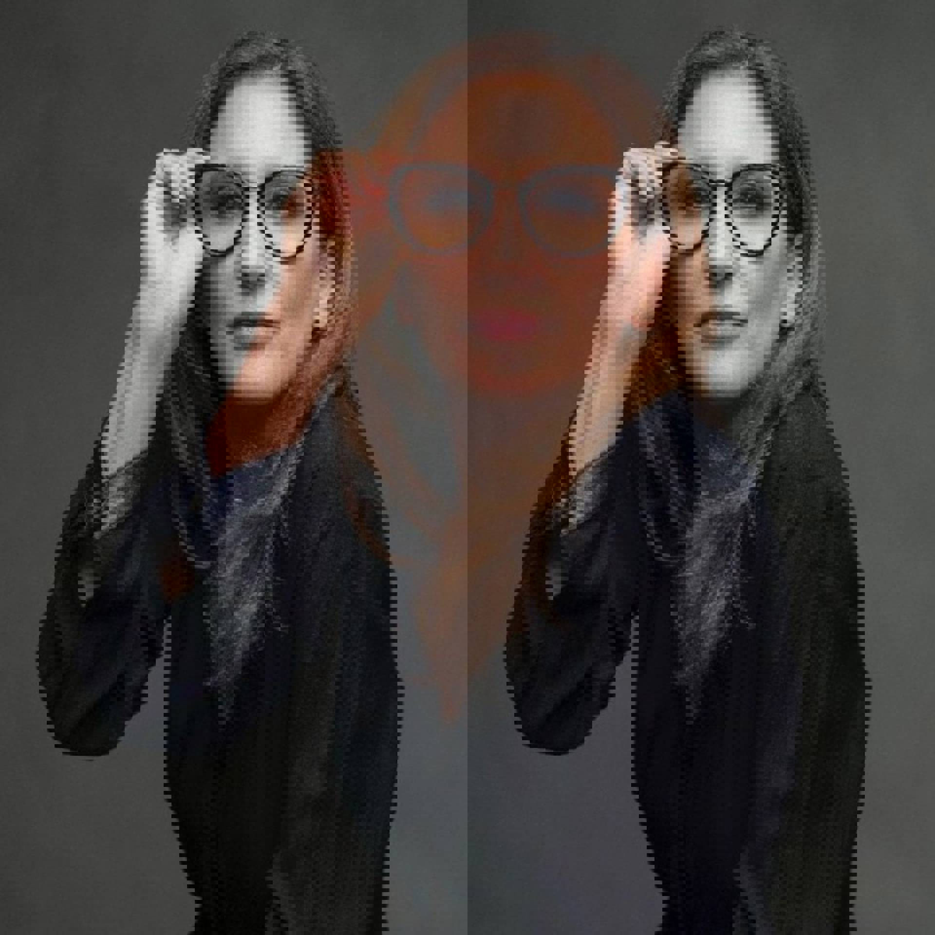 Headshot of a caucasian woman with long brown hair and dark eyes with a dark top on.