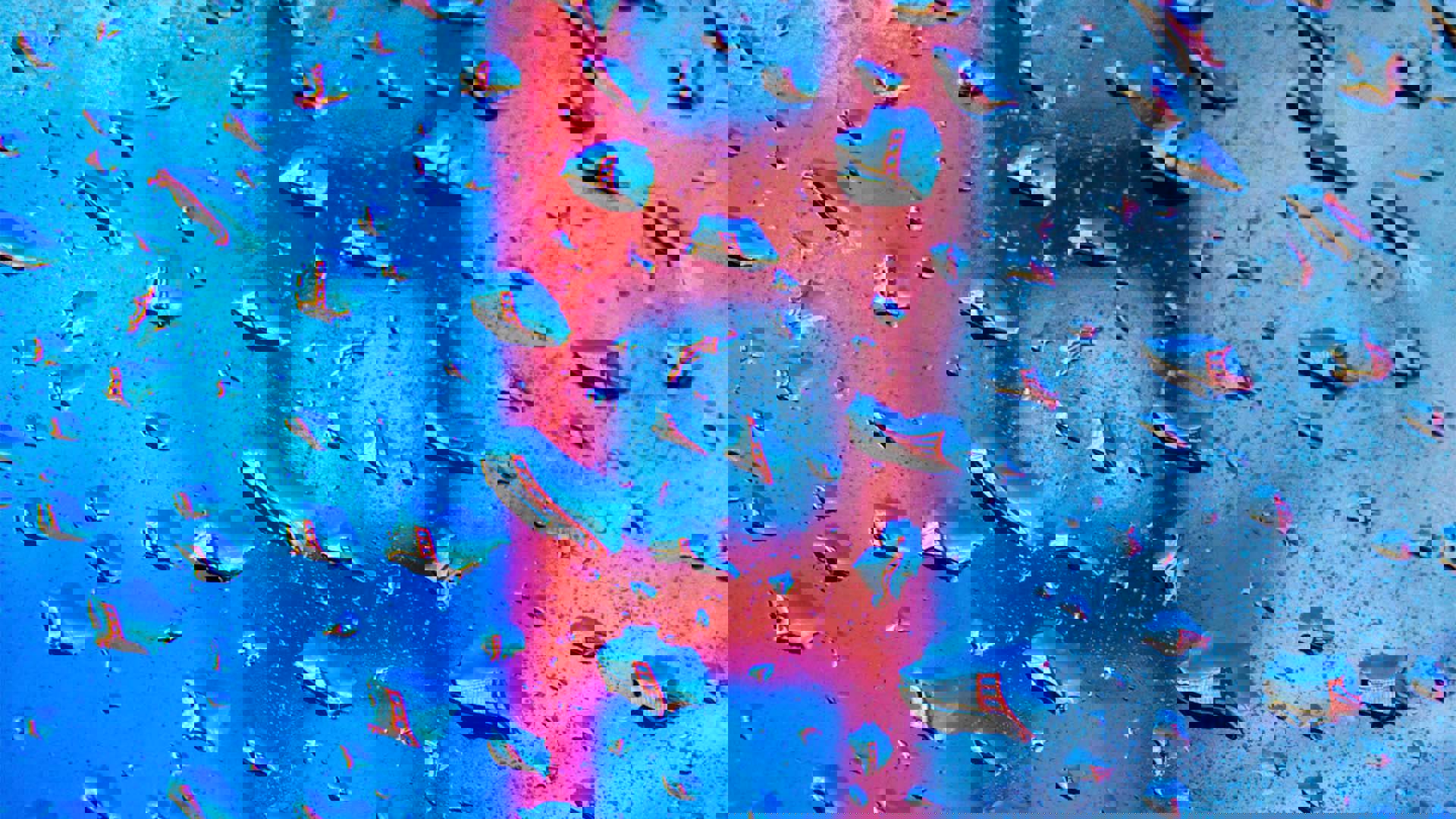 Water droplets against a glass surface with the Golden Gate Bridge blurred in the background.